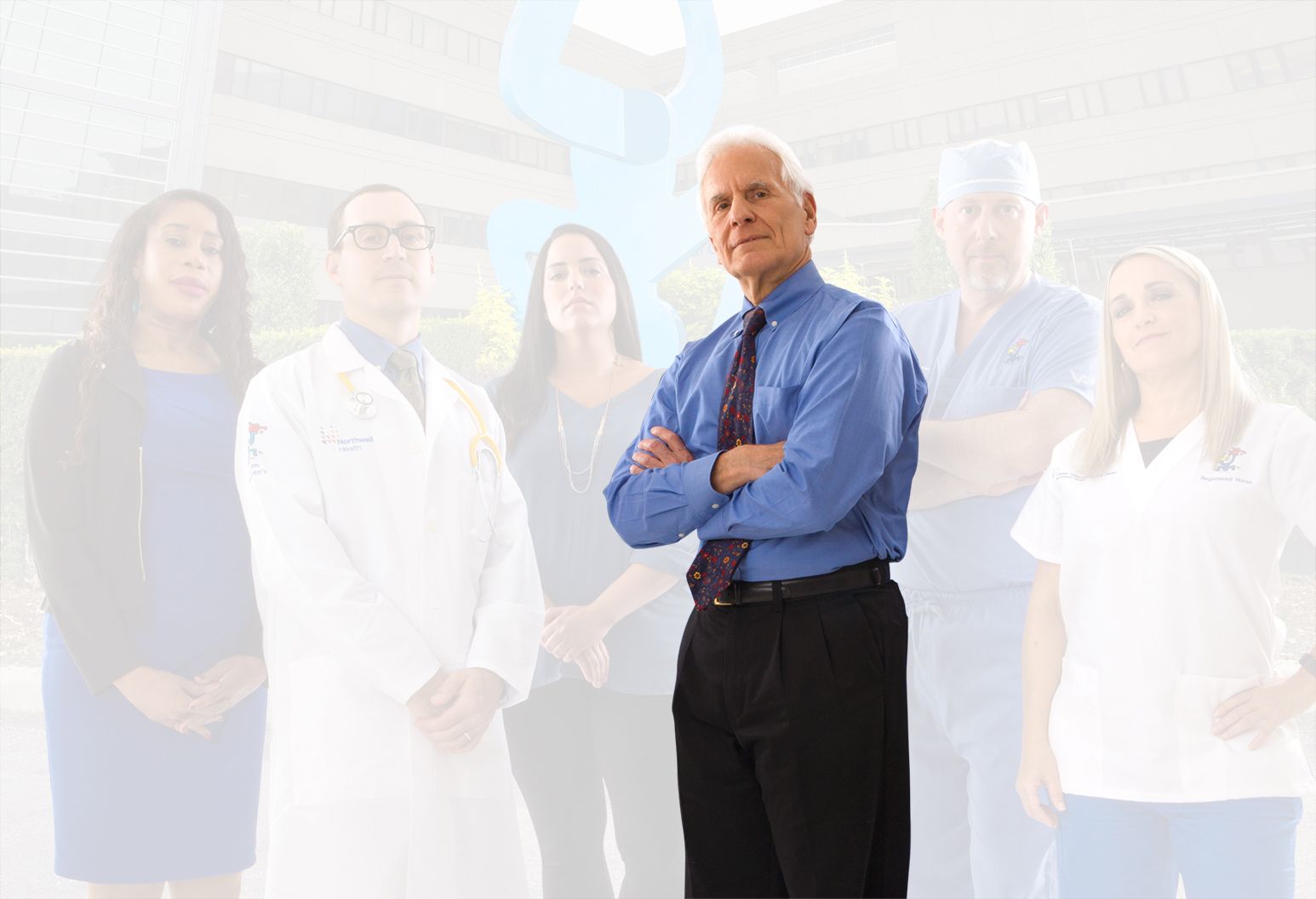 An experienced doctor separates from the rest of the team and the background. His arms are crossed heroically.